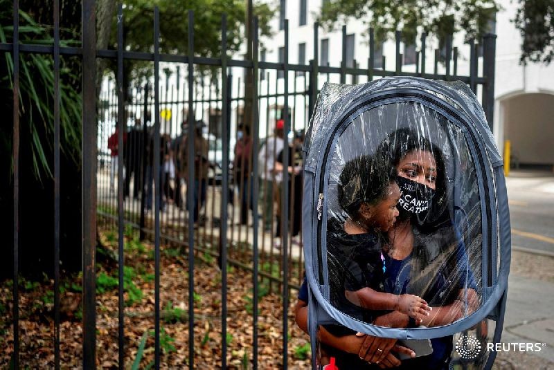 Dana Clark, and her son 18 month old Mason, wait in line at City Hall as early voting begins for the upcoming presidential election in New Orleans, Louisiana, U.S., October 16, 2020. REUTERS/Kathleen Flynn TPX IMAGES OF THE DAY